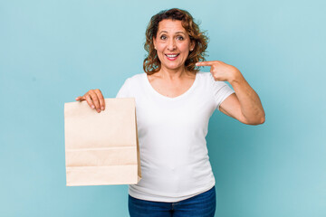 Wall Mural - middle age woman smiling confidently pointing to own broad smile. take away concept