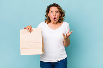 Wall Mural - middle age woman feeling extremely shocked and surprised. take away concept