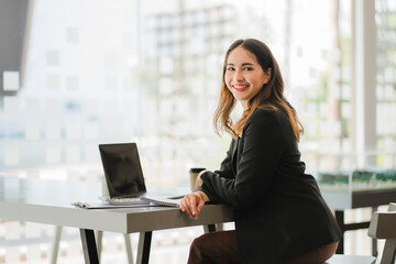 Smiling beautiful Asian businesswoman sitting with laptop and computer working on paperwork make an account analysis report real estate investment information financial and tax system concepts