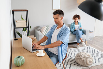 Wall Mural - Young man using laptop on table at home