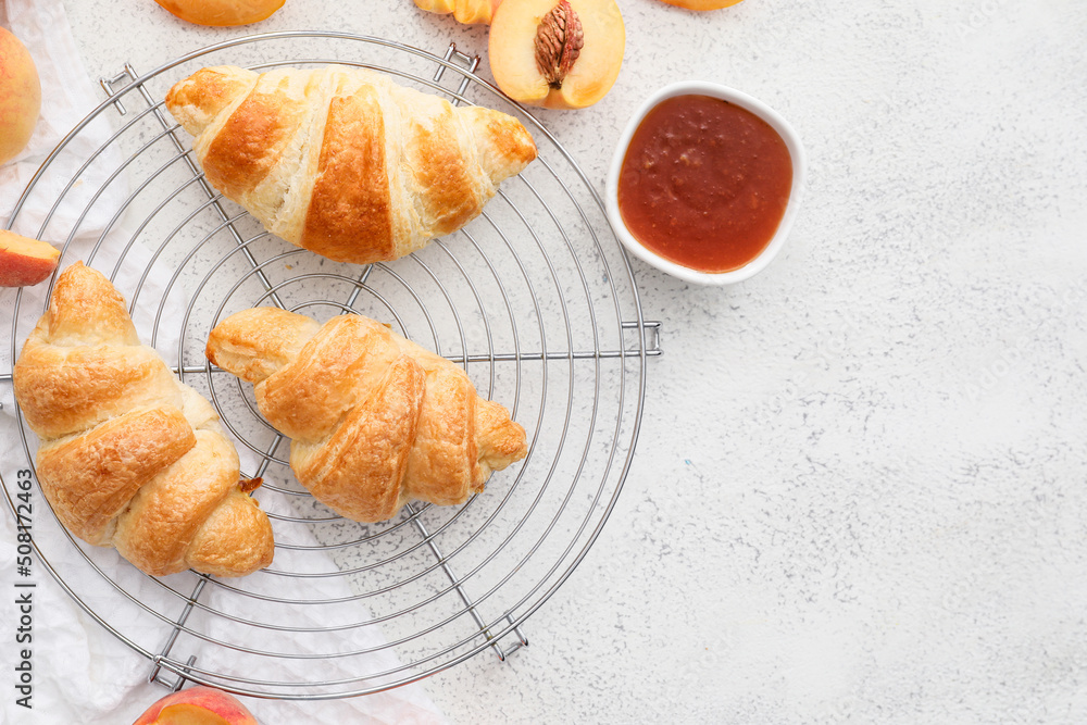 Grid of delicious croissants with peach jam on white background