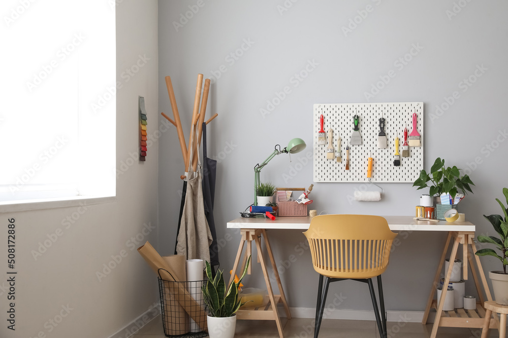 Decorator's workplace near light wall in room interior