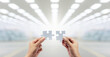 © ifriday - Two hands holding puzzle pieces to connect at factory. Teamwork concept idea.