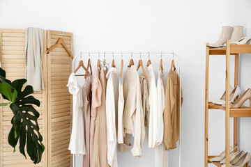 Wall Mural - Rack with stylish clothes near light wall in dressing room