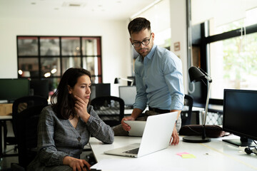 Colleagues in office. Businesswoman and businessman discussing work in office..