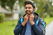 © Syda Productions - food shipping, safety and people concept - happy smiling delivery man with thermal insulated bag fastening his bicycle helmet on city street
