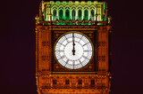 Fototapeta Big Ben - Big Ben of the Houses of Parliament London England UK at night striking midnight on new year's eve on Westminster Bridge which is a popular city landmark, stock photo image