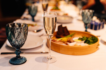 a glass of champagne on the festive table. traditional sparkling wine.