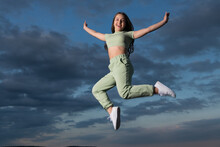 Happy Teen Girl Jump High On Sky Background