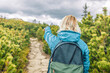 Young Caucasian hiker traveler with backpack adventure gesturing hand finds directions to the mountain nature. Technology internet and travel adventure concept. High quality photo