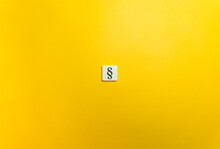The Section Sign, §, On Letter Tile On Yellow Background. Minimal Aesthetics.