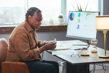 Wall Mural - Stressed senior African American man having a headache while playing bill online at home. Upset senior man worried about finance safety