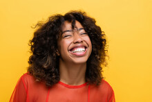 Overjoyed African American Woman Smiling With Closed Eyes Isolated On Yellow.