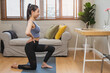 © Pormezz - Asian young female watching web and exercise at home