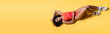 top view of brunette african american woman in beachwear lying on yellow background, banner.