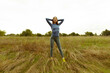 © YAROSLOVEPHOTOVIDEO - Young athletic Asian woman stands in a dry field. Brunette woman workout in nature