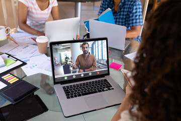 Poster - Businessman briefing work strategies to female colleague through video conference in office