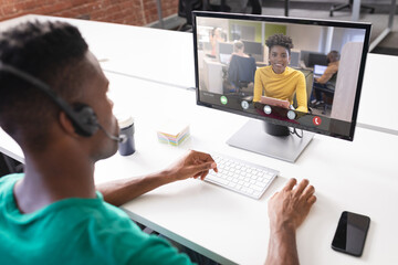 Canvas Print - African american businesswoman during video call with african american male colleague in office