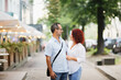 Cute European middle-aged couple hold hands and walk through the streets of the city,, summer walks and travel