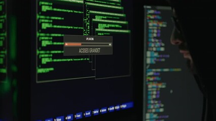 Dangerous hooded computer genius cracking database in dark room. Side view of cybercriminal getting unauthorized grandet access to personal banking data.