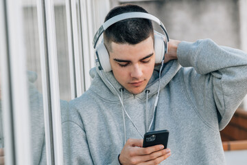 Canvas Print - teen boy with mobile phone and headphones