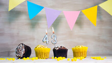Birthday Background With Number 43. Beautiful Birthday Card With Colorful Garlands, A Muffin With A Candle Burning Copyspace.