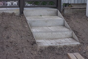 Poster - gray concrete steps on the stairs in the brown earth on the street