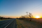 Fototapeta Nowy Jork - View of Two Lane Country Road in Texas With Sun Setting on the Right