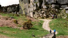 Hikers In Ilkley Moor Rock Formation In Yorkshire Dales England