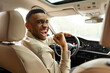 © Home-stock - Joyful african american man holding steering wheel shaking fist while sitting in car at car dealership