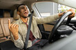 © Home-stock - Joyful afro american man dancing in car, singing while driving his car. Road fun