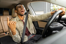 Joyful Afro American Man Dancing In Car, Singing While Driving His Car. Road Fun