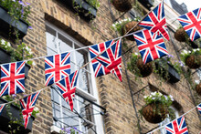 British Union Jack Flag Triangular Hanging In Preparation For A Street Party. Festive Decorations Of Union Jack Bunting. Selective Focus 