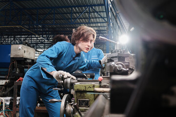 Professional young White female industry engineer worker works in safety uniform with metalwork precision tools, mechanical lathe machines, and spare parts workshop in the steel manufacturing factory.