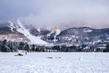 Wall Mural - People snowkiting on a cold winter day on Lake Tremblant near Tremblant ski resort in Quebec (Canada)