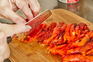 Poster - Chef cuts bell peppers into slices to prepare dish according to recipe from the Internet