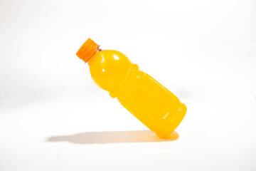 Bottle of fresh orange drink on white background