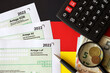 Leinwandbild Motiv German different tax declaration blank forms - Anlage EUR, Anlage SZ and Anlage Luf. Documents lies with calculator, pen and european money