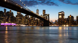 Fototapeta  - vue panoramique en pause longue sur Manhattan et le pont de Brooklyn le soir juste avant la nuit. Buildings et skyline illuminés