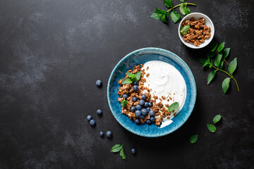 Canvas Print - Chocolate granola with white plain yogurt and fresh blueberry in a bowl, healthy food for breakfast, top view