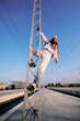 © chika_milan - Rebellious teenage girl climbing on the metal construction at the train station.