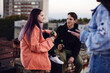 © chika_milan - Teenage friends chilling with bottles of beer at roof party.