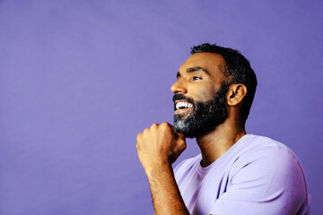 Wall Mural - profile headshot of a handsome smiling african american man with beard and mustache purple shirt looking away at copy space studio