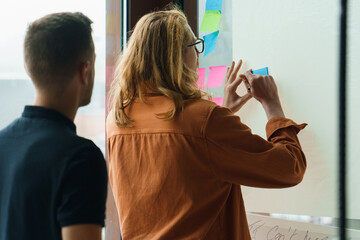 two people brainstorming with sticky notes
