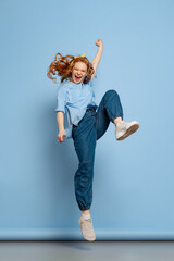 Astonished young redhead girl, student posing isolated on blue studio background. Human emotions, facial expression concept. Trendy colors