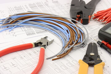 Tools for installing an electrical control panel in close-up on an electrical diagram.