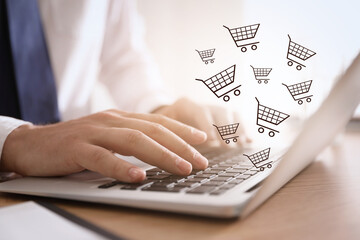 Man using laptop for online shopping at wooden table, closeup