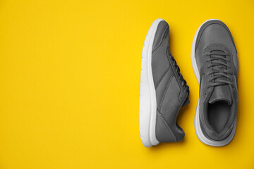 Wall Mural - pair of stylish sport shoes on orange background, flat lay. space for text