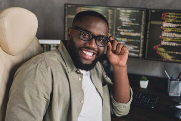 Portrait of attractive cheerful smart clever guy editing data developing web project touching specs at workplace workstation indoors