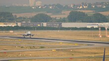 Footage of a jet civil aircraft landing, touching down and braking. Long shot of an airport airfield. Aviation industry concept